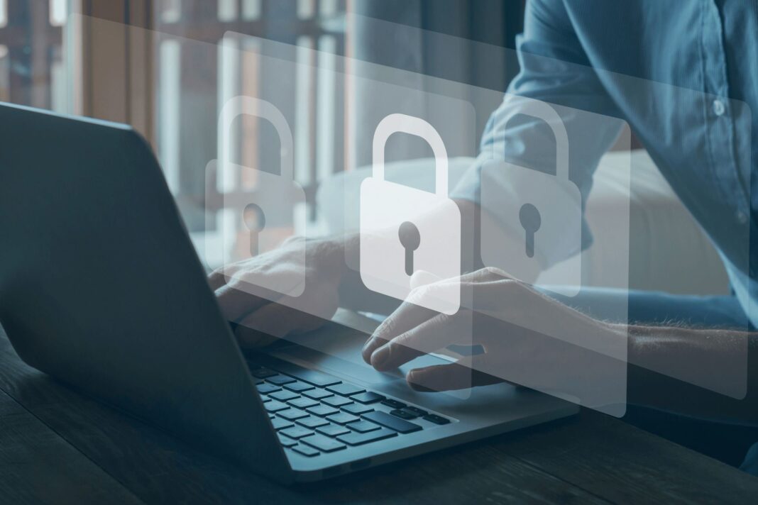 Immagine presa da Canva che raffigura un computer portatile e il simbolo del lucchetto. Utilizzata per l'articolo di giornale che tratta l'argomento della sicurezza informatica