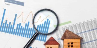 foto di copertina: grafici e report vicino al modellino di una casa