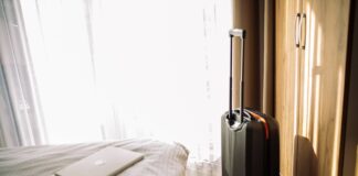 alloggio con computer sul letto e una valigia